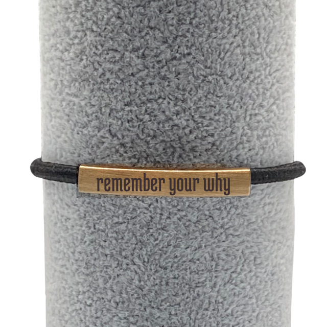 black elastic hair tie with gold bar engraved with "remember your why"